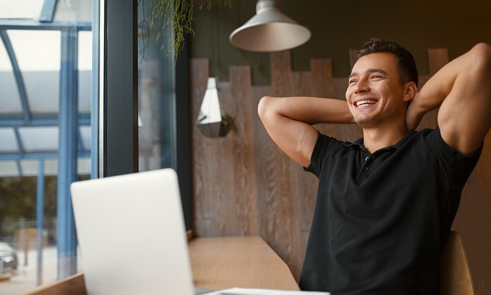 Relaxed man smiling at his desk — stress-free tax compliance
